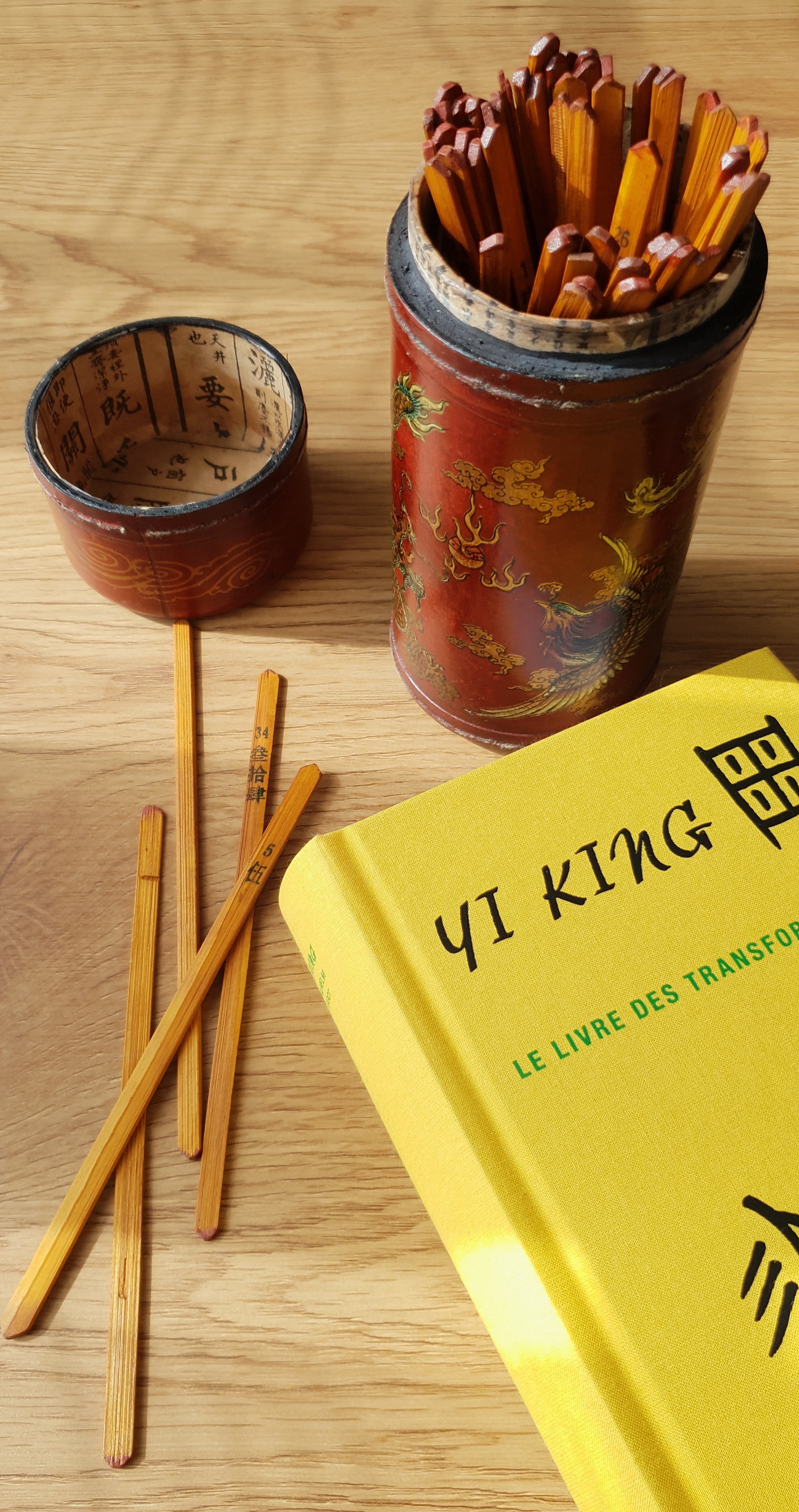 livre du yi king et baguette de bambou sur un bureau