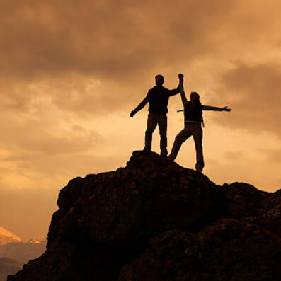 couple victorieux au sommet d'une montagne